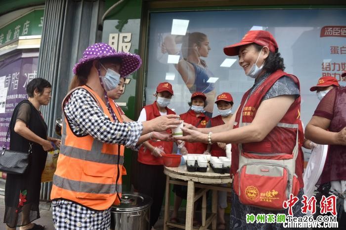 图为政和县老年志愿者为上早班的环卫工人免费发放凉茶。 徐钊 摄